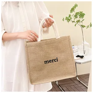Détail lifestyle d'un sac cabas en toile de jute naturelle avec imprimé 'merci'