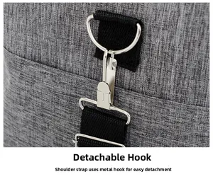 Detail of the durable silver metal detachable hook and black nylon strap on a grey travel bag