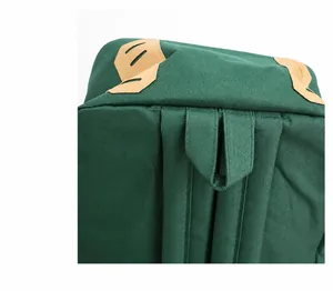 Detail of the green canvas backpack showing reinforced handle and strap stitching quality