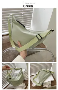 Detalle de bolso media luna de nailon verde claro con correa ajustable y cremallera