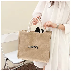 Détail d'un sac cabas en jute avec imprimé merci et poignées en corde de coton texturé