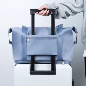 Light blue large capacity travel bag with luggage strap fixed on a white suitcase