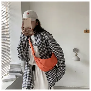 Primer plano del bolso media luna de nailon naranja brillante con correa ajustable