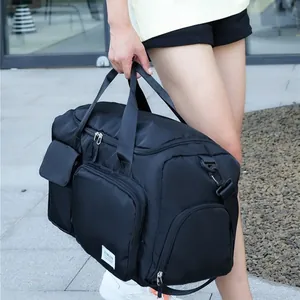 Detalle de una gran bolsa deportiva negra con asas reforzadas y etiqueta de marca