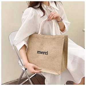 Détail du sac cabas en lin naturel avec lettrage merci noir et anse en tissu beige