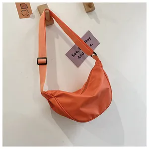 Primer plano del bolso bandolera de nylon naranja en forma de luna en gancho de madera