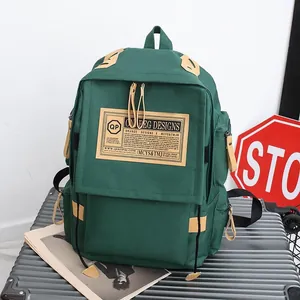 Groene vintage canvas rugzak met lederen details op een grijze koffer buiten