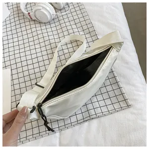 Detalle del forro interior negro y la capacidad del bolso de media luna de nailon blanco