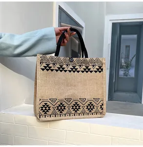 Detail of vintage jute tote bag with black geometric patterns and button closure