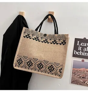 Detail of bohemian geometric pattern and texture on large jute tote bag with black handles