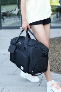 Detalle de bolsa de viaje negra impermeable con asas reforzadas y prácticos bolsillos