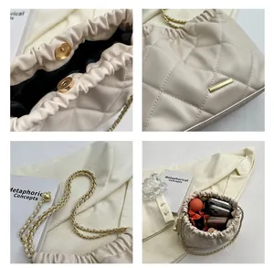 Detail view of cream quilted bucket bag showing internal capacity and gold chain strap