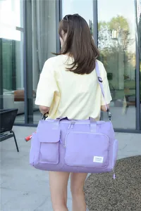 Detalle vista trasera de una gran bolsa de viaje lila para yoga con correa ajustable
