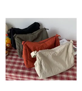 Détail de sacs bandoulière plissés en noir vert orange et beige pour femmes