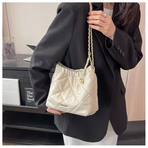 Detail of cream quilted bucket bag with golden chain and adjustable metal ball