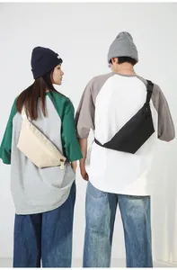 Moderne beige und schwarze Crossbody-Gürteltaschen an Models in lässiger Studio-Umgebung