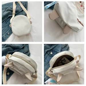 Vues détaillées du sac bandoulière mouton blanc montrant la broderie et l'espace interne