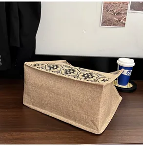 Detail shot of sturdy linen tote bag with black geometric patterns on a wooden table