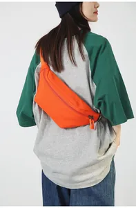 Detailaufnahme einer leuchtend orangen Brusttasche aus Nylon getragen von Model