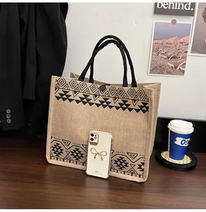 Close-up of jute tote bag with ethnic patterns and button closure on a wooden table