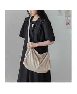 Détail du grand sac à bandoulière en tissu doux plissé de couleur crème et avoine