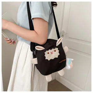 Détail du sac bandoulière mouton noir avec oreilles 3D et pendentif en peluche