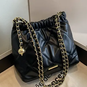 Chic black quilted bucket bag with golden chain strap and drawstring closure for women