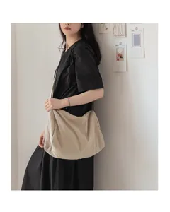 Détail du sac fourre-tout en tissu beige plissé montrant le drapé naturel et la bandoulière
