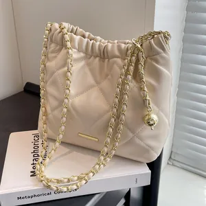 Quilted cream shoulder bucket bag with drawstring closure and golden chain strap