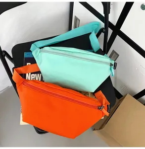 Details von minimalistischen Nylon-Gürteltaschen in Minzgrün und Orange mit Trägern