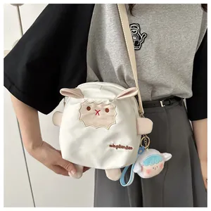 Détail du sac bandoulière agneau blanc avec broderie douce et pendentif en peluche mignon