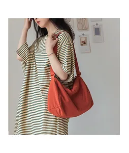 Vue détaillée du grand sac bandoulière en toile orange au design plissé chic