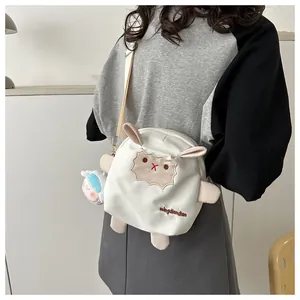 Détail du sac bandoulière mouton blanc mignon avec poupée en peluche sur robe grise
