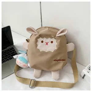 Détail du sac bandoulière mouton kaki avec breloque en peluche et sangle ajustable
