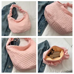 Vues détaillées d'un sac à main rose plissé avec texture gaufrée et espace de rangement