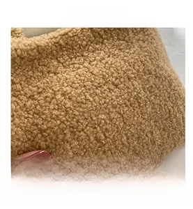 Close-up of the thick brown teddy plush fabric showing soft grainy texture of the tote bag