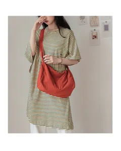 Détail d'un grand sac bandoulière plissé rouge brique en toile dans un style de vie décontracté