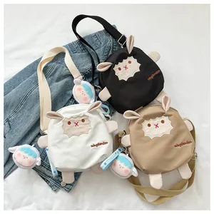 Trois sacs bandoulière agneau mignons en blanc noir et kaki avec pendentifs poupée