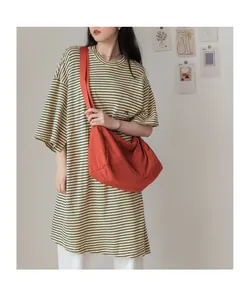 Détail du grand sac bandoulière plissé en toile rouge brique avec une large bandoulière