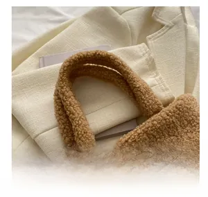 Detail of plush brown teddy fabric handbag handle with soft texture in winter scene