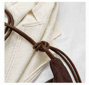 Close-up of the suede crossbody bag featuring unique leather knot craftsmanship and texture