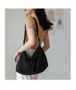 Vue latérale d'un grand sac hobo en nylon noir montrant la capacité et le drapé
