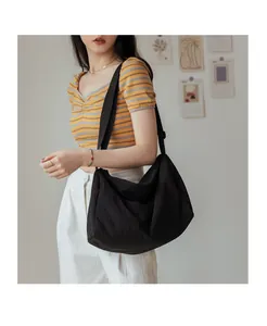 Détail du sac bandoulière minimaliste en nylon noir avec sangle réglable et tissu durable