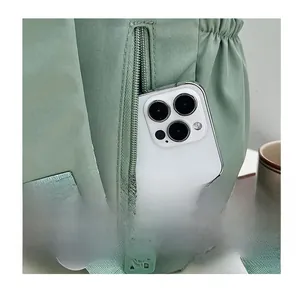 Detail of rear anti-theft zipper pocket on light green backpack with smartphone storage