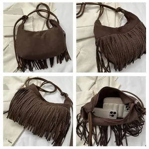 Macro detail of dark brown suede tassel hobo bag with fringe texture and metal zipper