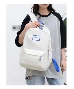 Close-up of cream backpack with blue accents and brand logo on durable nylon fabric