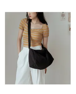 Gros plan sur le sac bandoulière noir minimaliste avec texture de tissu froissé