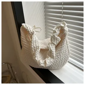 Détail du tissu à bulles blanches sur un sac à bandoulière minimaliste pour femmes