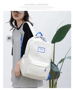 Minimalist beige backpack with blue accents and side pocket worn by model