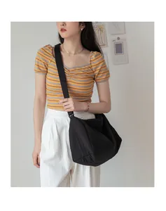 Détail d'un grand sac bandoulière plissé noir avec une large bandoulière réglable